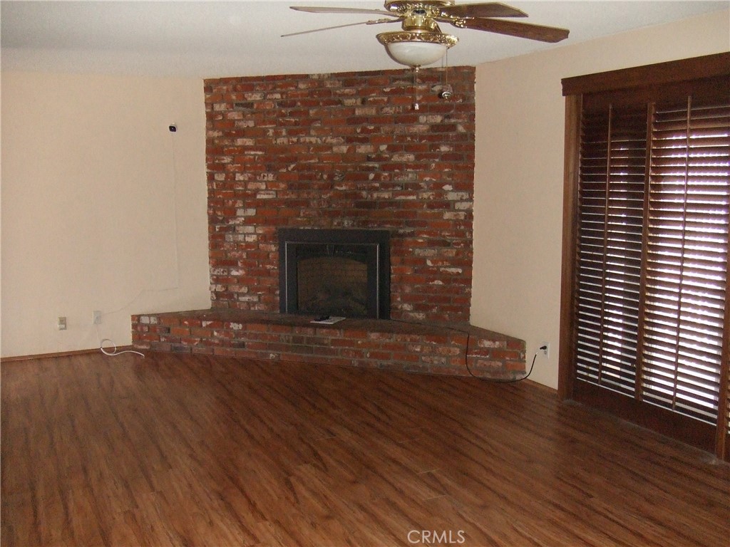 15100 Blackfoot Road Apple Valley, CA 92307 - Photo 4 of 18 a view of empty room with wooden floor and fireplace