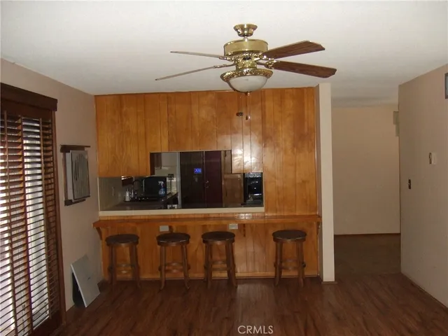 a kitchen with stainless steel appliances a dining table chairs and wooden floor