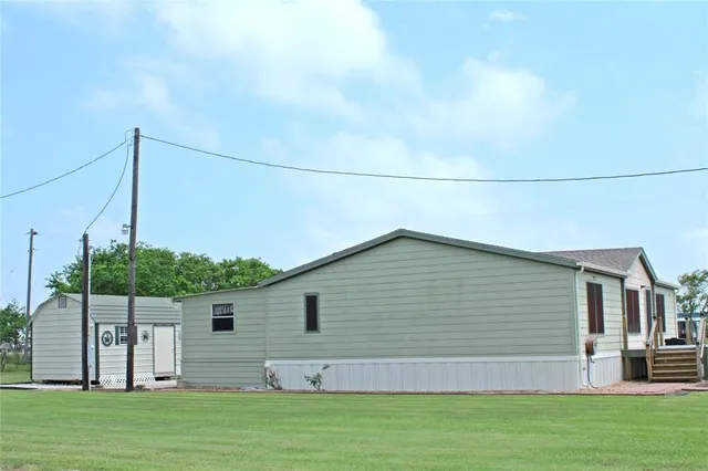 a view of a swimming pool with lawn chairs and a big yard