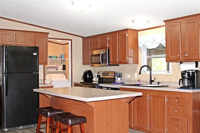 a kitchen with stainless steel appliances a sink cabinets and a refrigerator