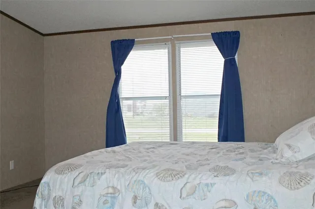 a bedroom with a bed and a large window