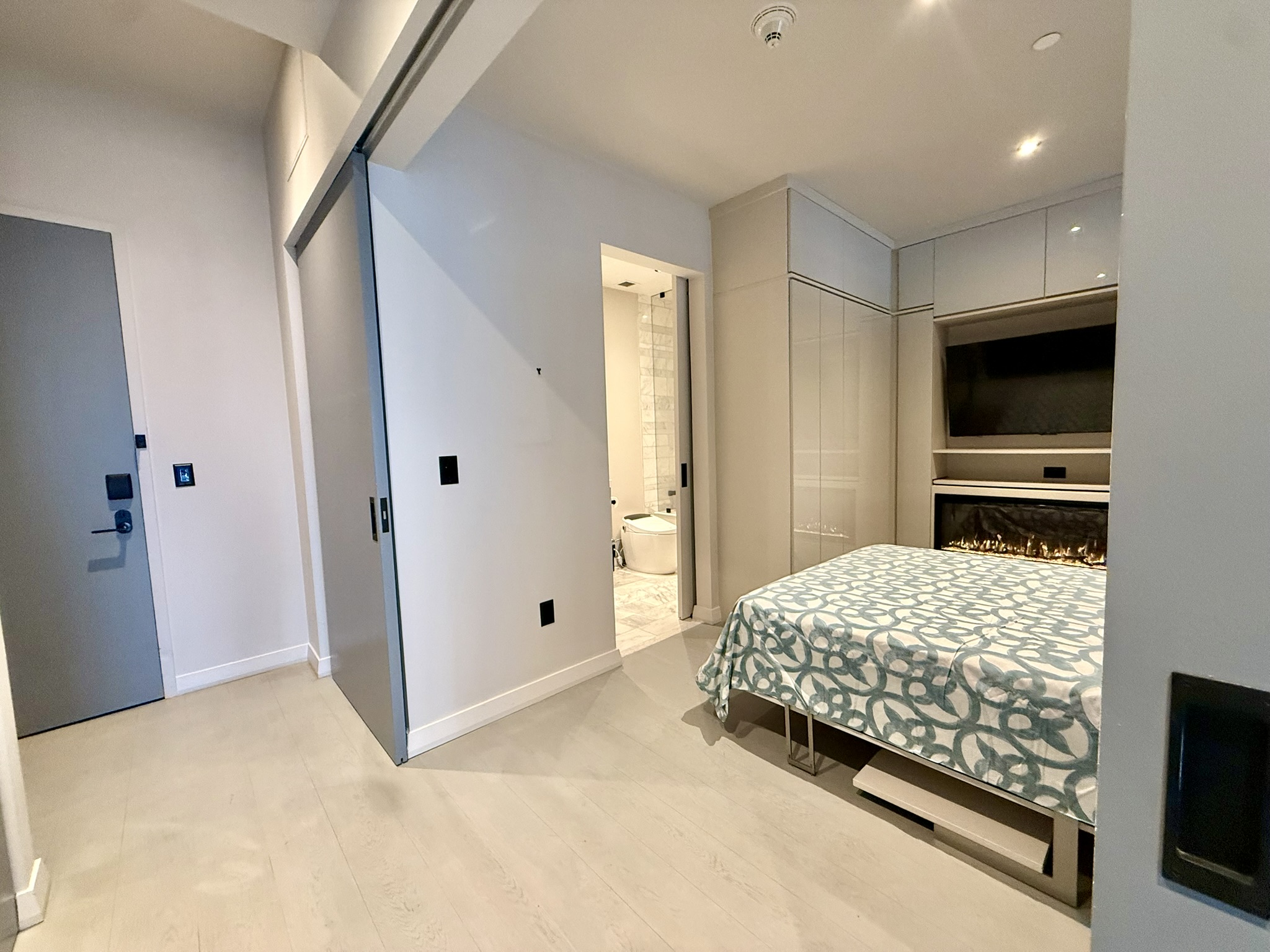 210 Lavaca Street, Unit 2809 Austin, TX 78701 - Photo 10 of 17 An inviting bedroom offering a modern fireplace and discreet built-in storage.