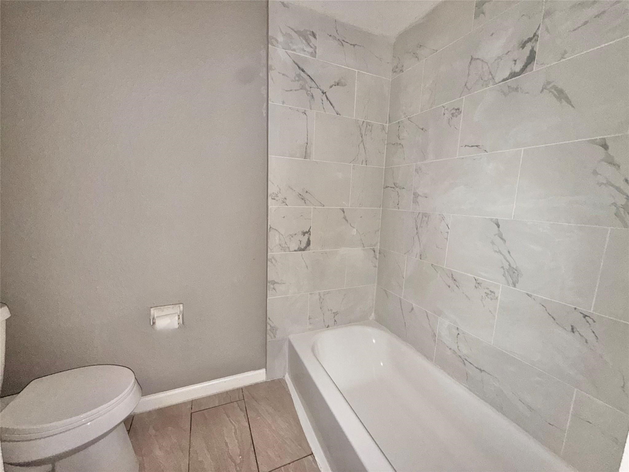 5418 Weaver Road, Unit D Houston, TX 77016 - Photo 5 of 10 a bathroom with a bathtub and a toilet