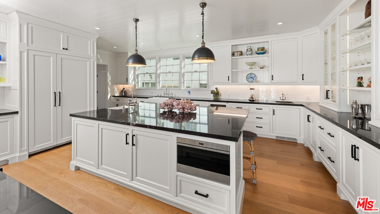 605 Palisades Beach Road Santa Monica, CA 90402 - Photo 4 of 33 a large white kitchen with stainless steel appliances granite countertop a stove a sink and white cabinets