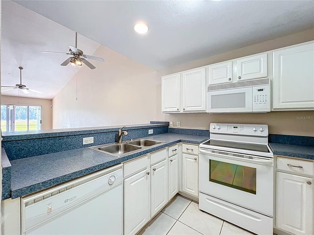 100 Silver Sea Road Winter Springs, FL 32708 - Photo 10 of 44 a kitchen with cabinets stainless steel appliances a sink and a stove