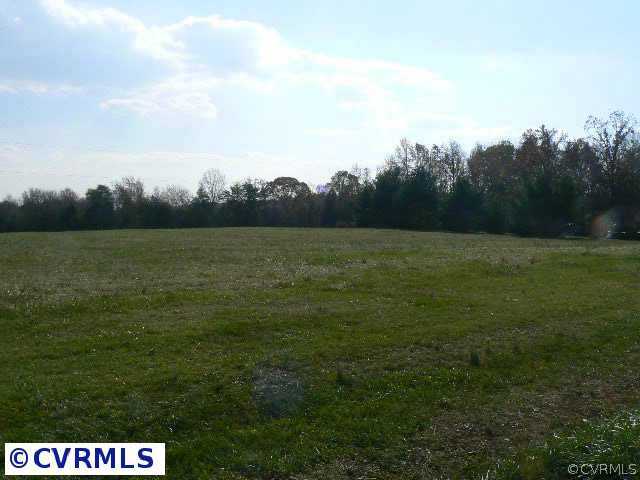 a view of field with trees in background