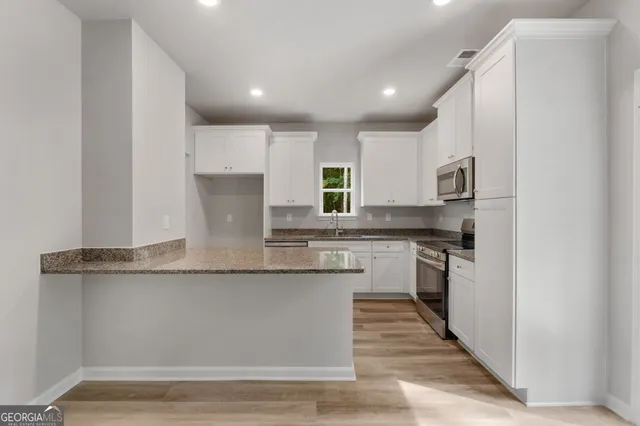 a kitchen with stainless steel appliances granite countertop a stove a sink and a refrigerator