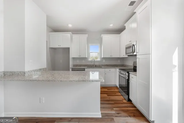 a kitchen with stainless steel appliances granite countertop a sink and a refrigerator