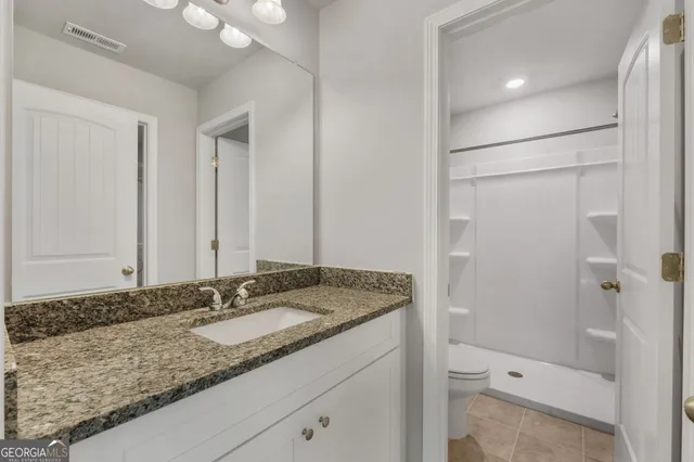 a bathroom with a granite countertop sink and a mirror