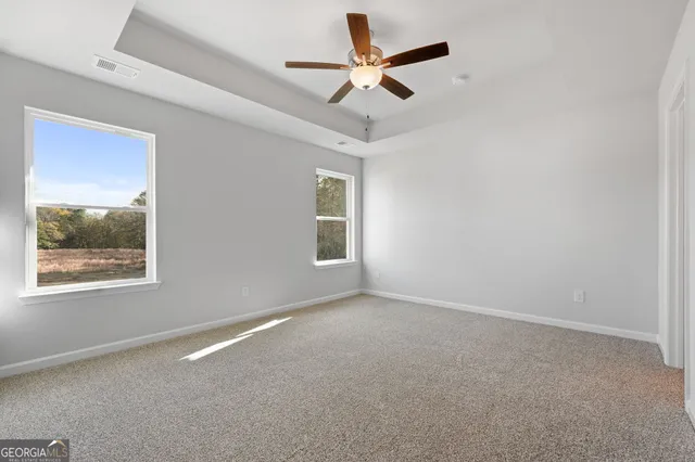 an empty room with a window and a fan