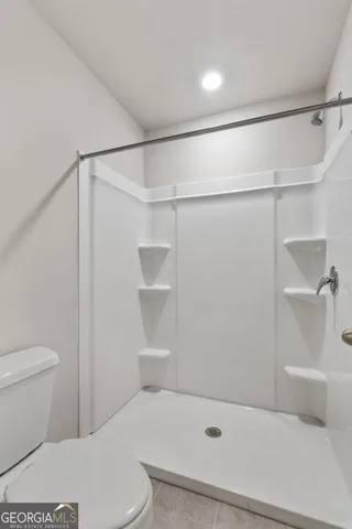 a bathroom with a shower a toilet and a shower
