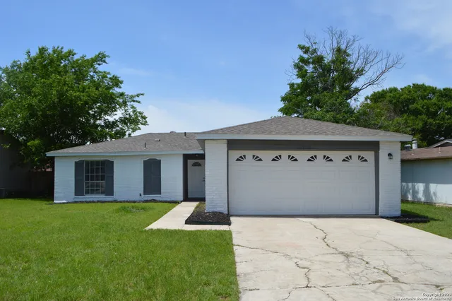 a front view of house with yard and garage