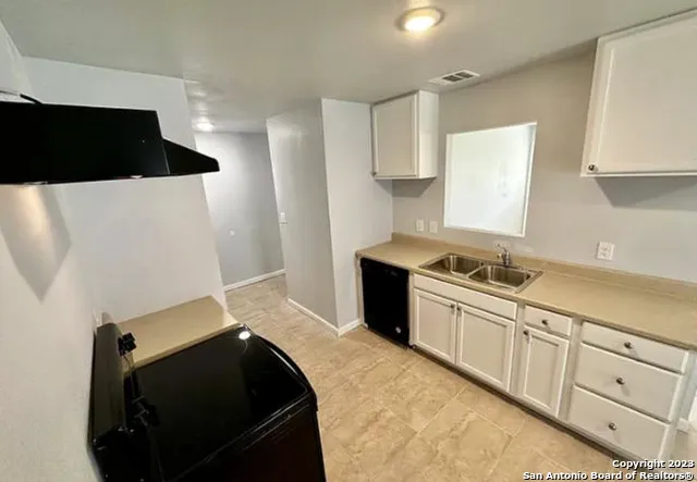 a kitchen with a sink and a stove top oven