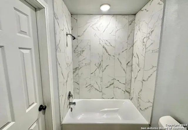 a bathroom with a bathtub and shower