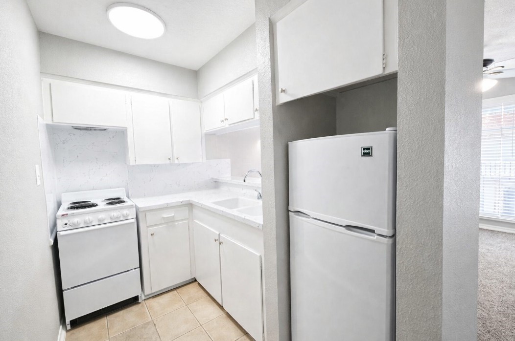 414 Marshall Street, Unit 21 Houston, TX 77006 - Photo 5 of 7 a kitchen with a refrigerator sink stove and cabinets