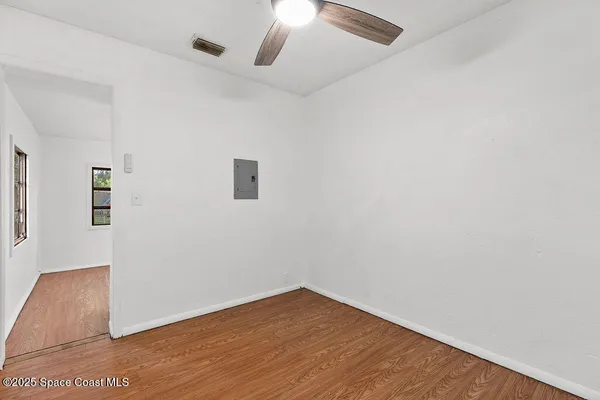 an empty room with a window and wooden floor