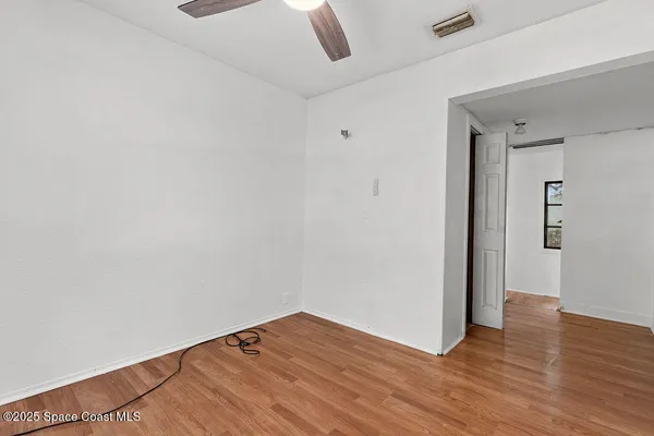 an empty room with a window and a ceiling fan