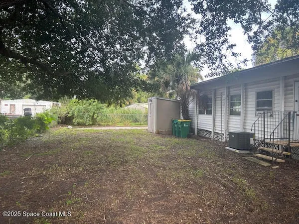 a view of a house with backyard and a tree