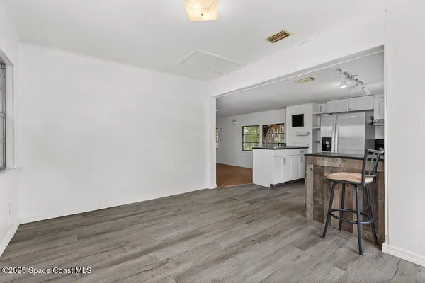 a kitchen with wooden floor and white cabinets