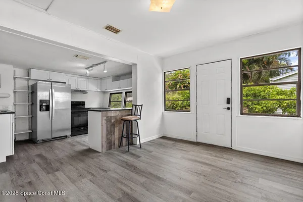 a kitchen with stainless steel appliances wooden floor and window