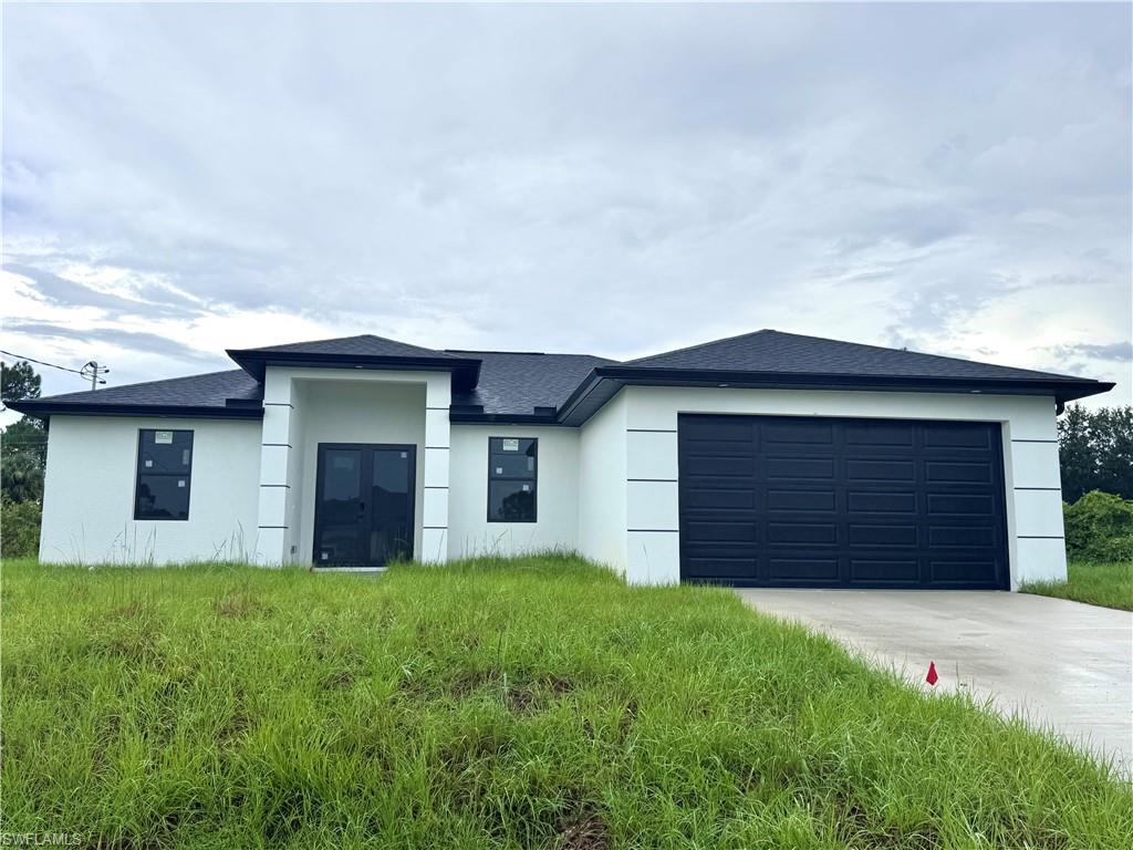 a front view of house with yard and garage