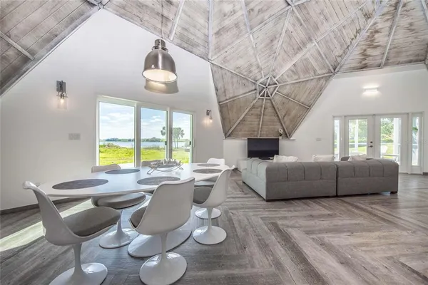 a view of a patio with table and chairs potted plants with floor to ceiling window