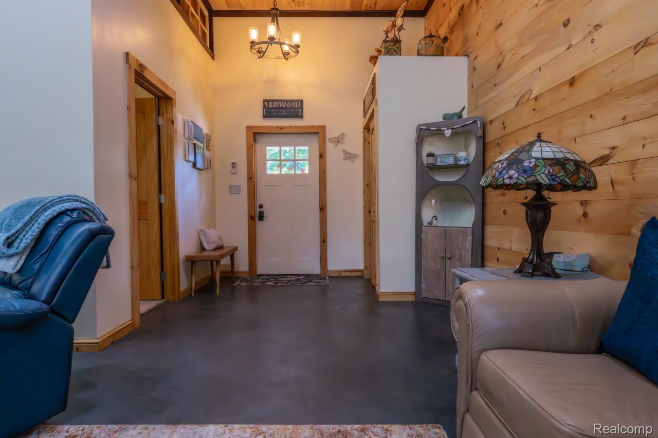 2418 South 41st Road South Cadillac, MI 49601 - Photo 5 of 57 Entryway featuring a paneled door with glass inserts, robust wood trim, and dark-finish flooring