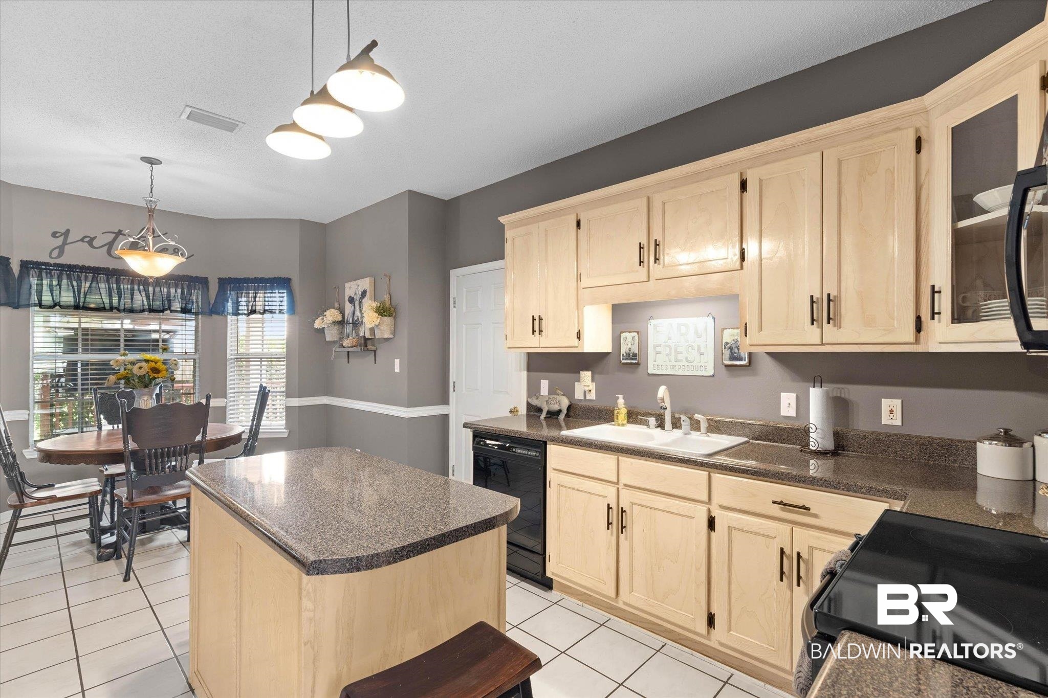 3170 Scott Dairy Loop Road West Mobile, AL 36695 - Photo 7 of 24 Kitchen featuring a central island with a granite-style countertop, light wood cabinetry, white tile flooring, and a dining area with multiple windows