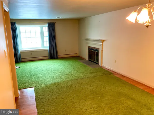 a view of an empty room with a fireplace and a window
