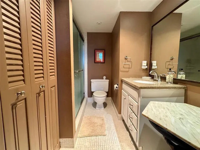 a bathroom with a granite countertop sink a toilet and a mirror