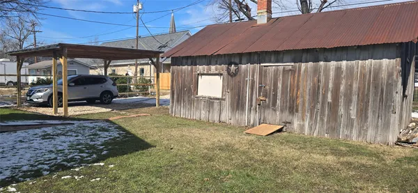 a backyard of a house with barbeque oven table and chairs