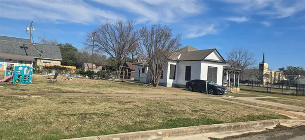 a view of a yard with a house in the background