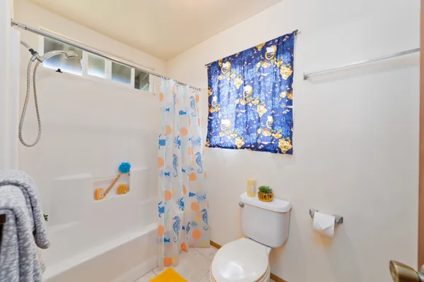 a white toilet sitting next to a bathroom sink and a bath tub