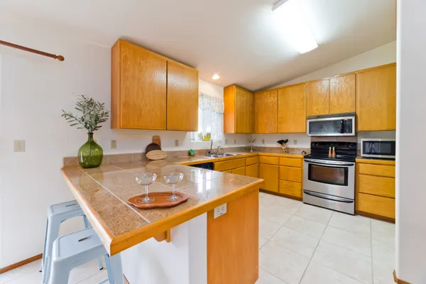 a kitchen with stainless steel appliances granite countertop a sink counter space cabinets and a stove