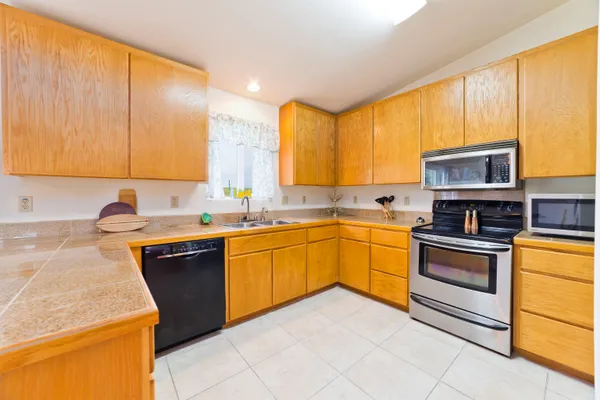 a kitchen with stainless steel appliances granite countertop a sink counter space and a window