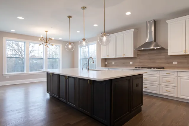 a kitchen with kitchen island granite countertop a sink appliances and cabinets