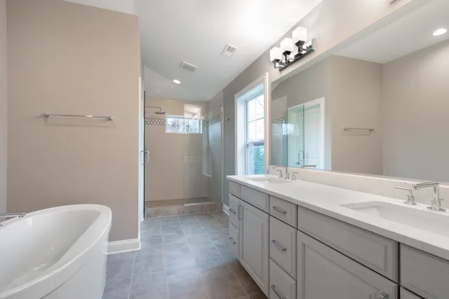 a spacious bathroom with a granite countertop sink a toilet and a bathtub