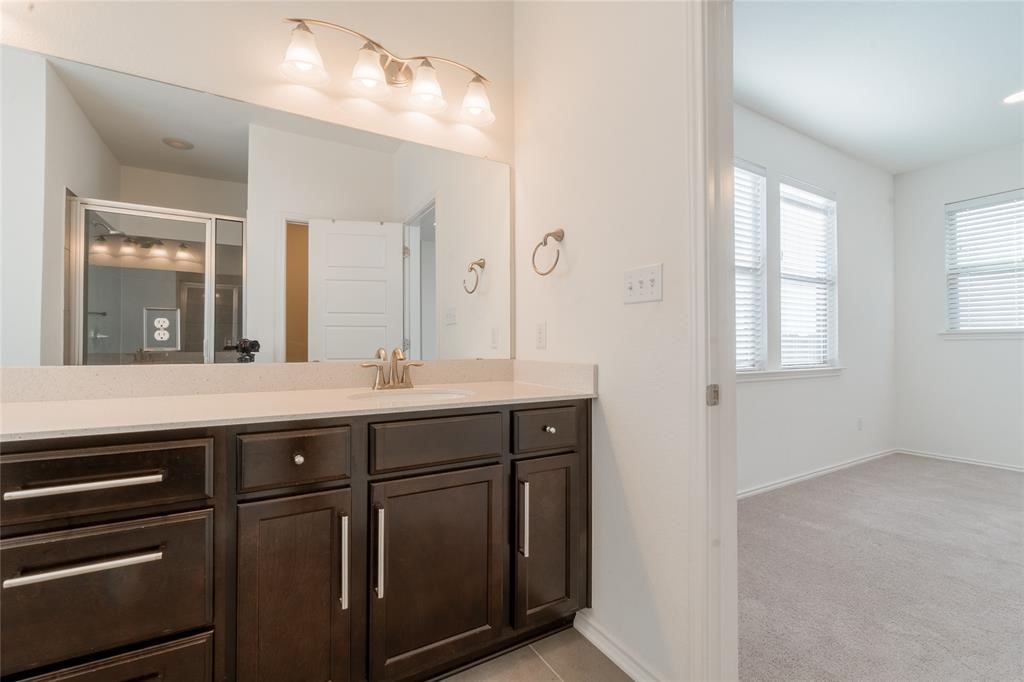 1333 Terrace View Drive Georgetown, TX 78628 - Photo 31 of 35 A well-appointed vanity with generous counter space, dark wood cabinetry, and an illuminated mirror anchors this private bathroom.