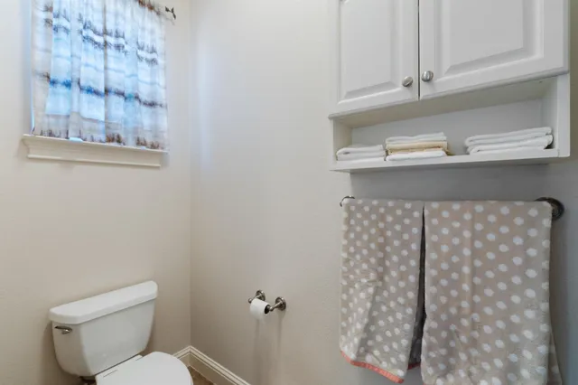 a white toilet sitting next to a shower