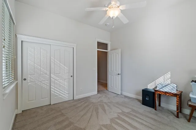 an empty room with wooden floor closet and windows