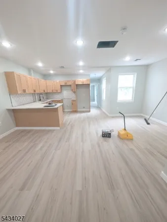 a living room with kitchen view and a wooden floors