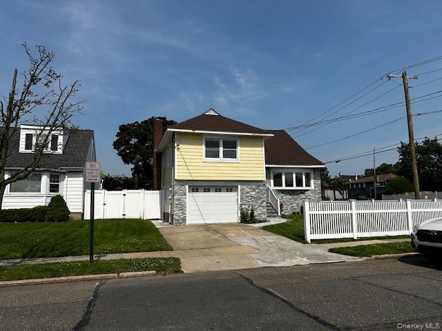 558 Oxford Road Cedarhurst, NY 11516 - Photo 1 of 22 View of front of home with stone siding, a garage, driveway, a gate, and a chimney
