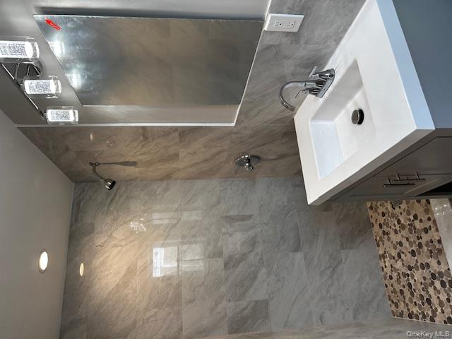 558 Oxford Road Cedarhurst, NY 11516 - Photo 13 of 22 Bathroom with tile walls, vanity, tiled shower, and tasteful backsplash