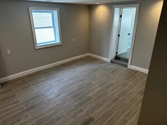 an empty room with wooden floor and mirror