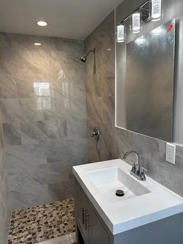 a bathroom with a sink a toilet and shower
