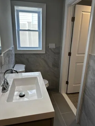 a bathroom with a sink a window and shower