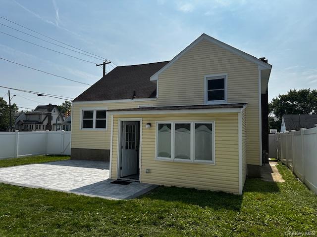 558 Oxford Road Cedarhurst, NY 11516 - Photo 19 of 22 Back of house with a patio, a fenced backyard, and roof with shingles