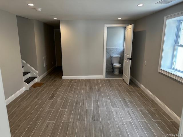 558 Oxford Road Cedarhurst, NY 11516 - Photo 21 of 22 Empty room with wood tiled floors, recessed lighting, and stairway