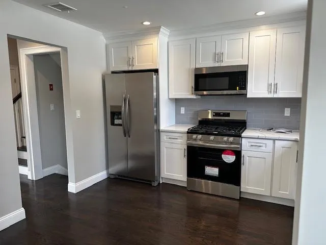 a kitchen with stainless steel appliances a refrigerator stove and microwave