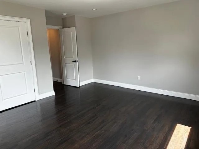 an empty room with wooden floor and cabinet